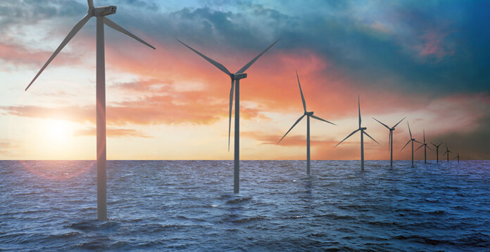 Offshore wind turbines in a line with beautiful orange sunset in the background