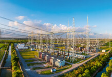 Substation virtualisation: Automation for future grids Image of transmission towers connecting to a substation with bright blue sky overhead
