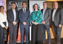 First Australian study on quantum timing to strengthen grid Six researchers and executives pose for photo in front of Swinburne and Siemens signage at event