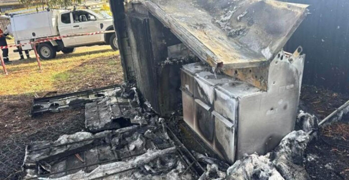 Charred substation equipment with a work vehicle in the background