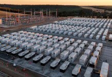 Behind the scenes of Australia’s biggest battery build Aerial shot of battery units at large battery storage project with sunset in background