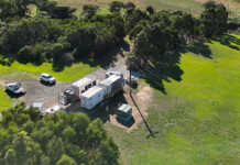 Powercor bolsters town’s power backup to withstand outages Aerial shot of power generators and vehicles at site surrounded by lush green grass and trees