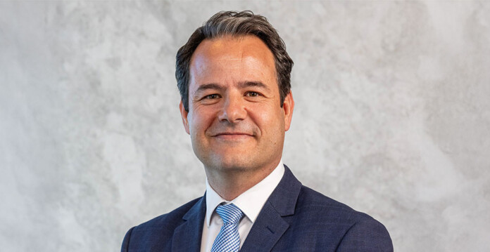 Head and shoulders shot of smiling male executive wearing a suit and tie