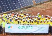 Iberdrola completes panel install at Broadsound Solar Farm Huge construction crew in hard hats and high-vis vests stand in front of solar panels at solar farm holding sign announcing completion of solar installation at Broadsound Solar Farm