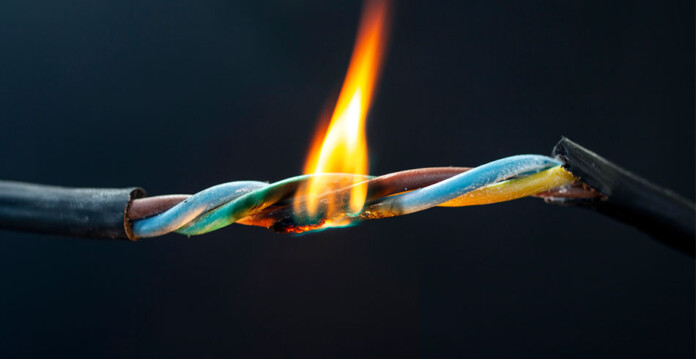 Close up shot of a flame burning a frayed electrical wire