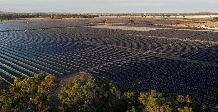 Aerial shot of a solar farm among green bushland.