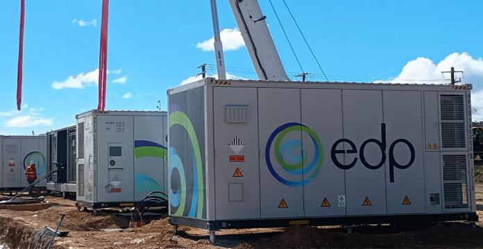 Battery storage units being lifted into place by a crane