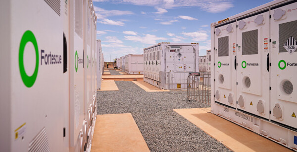 Battery storage units with Fortescue logo installed in remote sandy location