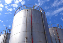 The government’s plans to bolster Australia’s fuel stores are sensible, but five years too late Three large concrete and steel fuel storage tanks with blue cloudy sky overhead