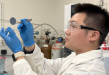 Membrane breakthrough boosts high-efficiency fuel cells Researcher wearing white coat and blue gloves handles small membrane in laboratory