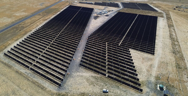 aerial shot of solar farm in grassy rural landscape