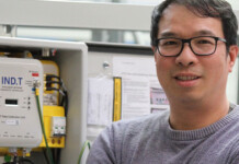 Investing where it matters most to reduce risk in the grid Man wearing glasses and sweater stands in front of grid technology solution bearing IND Technology logo
