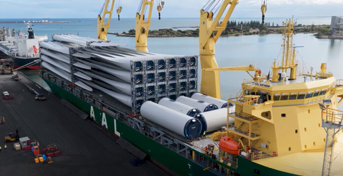 Cargo ship with wind turbine components onboard at a port