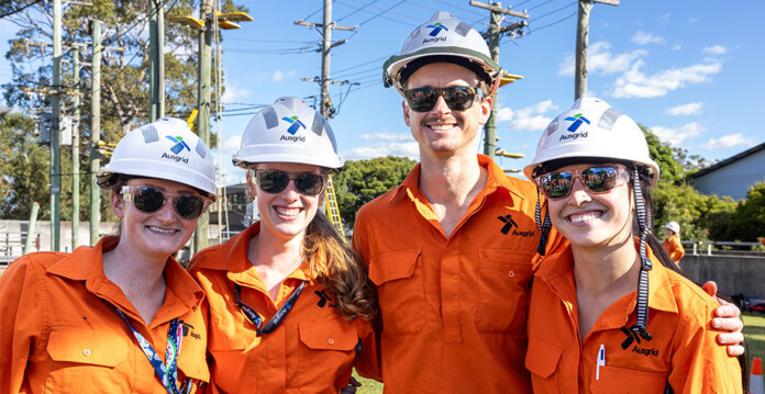 Four apprentices in Ausgrid hard hats and work uniforms