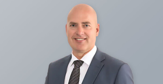 dean-nalder Head and shoulders shot of a smiling male executive wearing a suit and tie