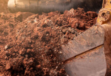 Australia lags best practice on underground utility strikes close-up of digger bucket full of soil during excavation work
