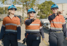 Apprentices needed to power Western Sydney Aerotropolis Three young female energy workers walking together outside wearing caps and high-vis workwear