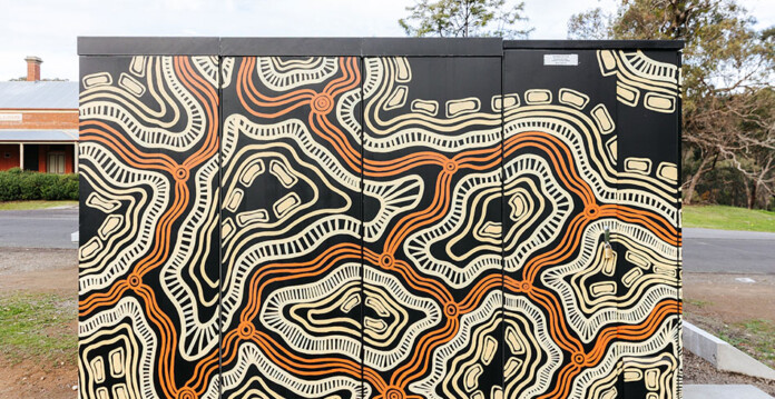 Close up of community battery adorned in Aboriginal artwork
