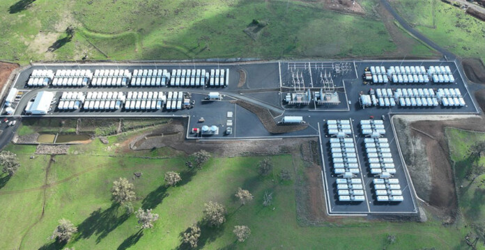 Aerial photo of large battery energy storage system set in lush green landscape