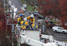 Powercor takes town off electricity to upgrade network Electricity crews in lift cranes work on electricity lines in rural town