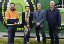Western Power to build 18 community batteries in WA Four people stand in front of wall with Aboriginal art design for photo