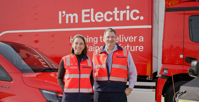 Australian Minister for Communications Anika Wells and Australia Post Executive General Manager, Network Operations Shane Plant pose for photo in front of bright red electric truck
