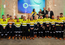 Fortescue launches new training centre for electricians Group of apprentices poses for photo in front of Fortescue logo on screen
