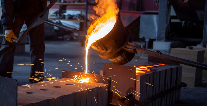 Molten metal being poured from large vat during processing