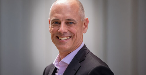 Head and shoulders shot of smiling man wearing a suit jacket and business shirt