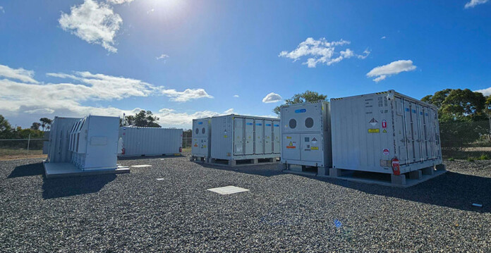 Battery units at the grid-scale Strathalbyn Battery Energy Storage System (BESS) underneath blue sky and white clouds