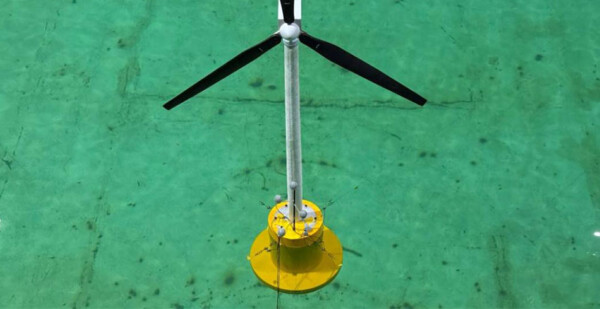 Floating wind turbine prototype sitting in green test pool 