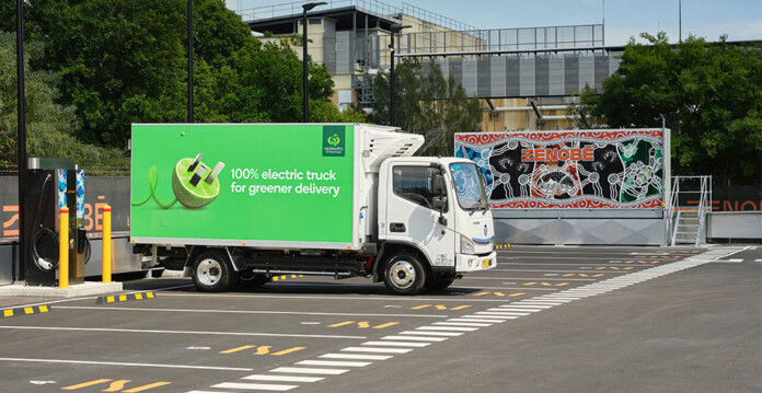woolworths-zenobe Rendered image of an electric Woolworths-branded delivery truck in front of Zenobe signage in a car park