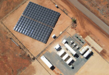 Tiny Western Australian town to run on 80% renewables Aerial photo of solar farm and battery energy storage system set in red dirt of remote regional town