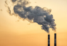 New technology could turn factory fumes into useful fuels Smoke pours from chimney stacks at industrial factory with hazy orange sky overhead