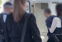 Solar company manager charged with alleged bribery attempt Police officers surround a police van while a handcuffed man with his face blurred is moved towards the vehicle