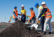 Construction begins at Steel River East BESS Executives in high-vis vests and hard hats turn first sod at battery project site with blue sky overhead