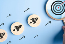 New ARENA program to fund clean energy startups small wooden discs with rocket motifs are positioned heading towards a magnifying glass with a target icon inside it