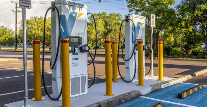 Two public Evie Networks EV charging bays with urban street and trees in background